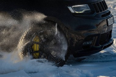 Aşırı sürüş, araba yumuşak karın üzerinde hızla hareket ediyor ve bir kar püskürtüsü oluşturuyor. Yüksek kalite fotoğraf