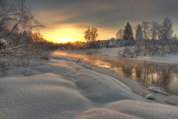 Soluppgång över frostiga floden Stockbild