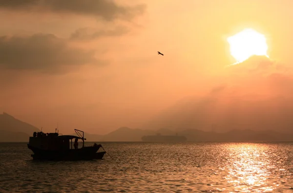 Horgászcsónak naplemente közelében hong kong. — Stock Fotó