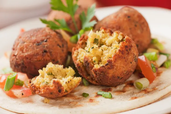 Falafel, frittierte Kichererbsenbällchen auf Fladenbrot — Stockfoto