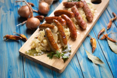 Lahana ya da lahana turşusuyla servis edilen ızgara Alman sosisi.