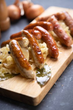 Lahana ya da lahana turşusuyla servis edilen ızgara Alman sosisi.