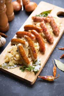 Lahana ya da lahana turşusuyla servis edilen ızgara Alman sosisi.