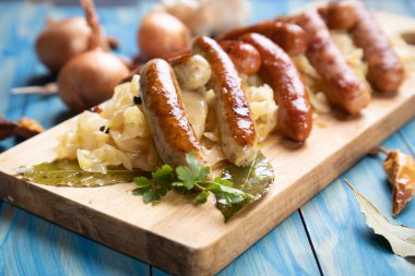 Lahana ya da lahana turşusuyla servis edilen ızgara Alman sosisi.