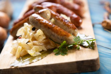 Lahana ya da lahana turşusuyla servis edilen ızgara Alman sosisi.