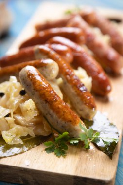 Lahana ya da lahana turşusuyla servis edilen ızgara Alman sosisi.