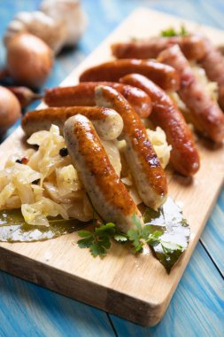 Lahana ya da lahana turşusuyla servis edilen ızgara Alman sosisi.