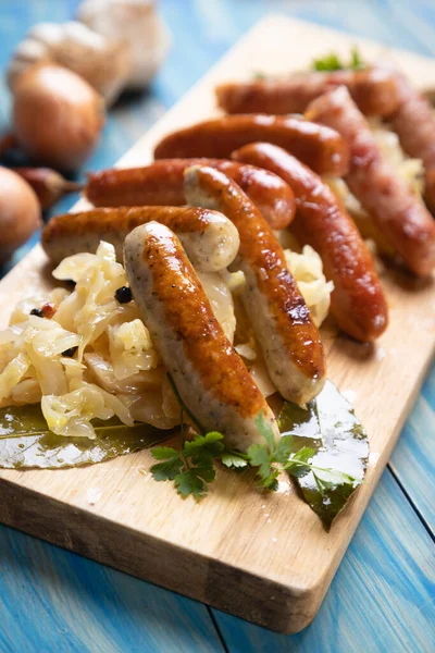 Lahana ya da lahana turşusuyla servis edilen ızgara Alman sosisi.