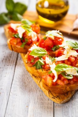Klasik İtalyan bruschette ızgara ekmek dilimleri domates, fesleğen ve mozzarella peyniri.