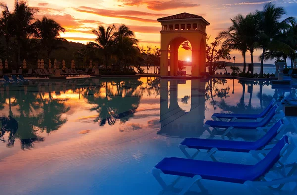 Pavilhão em um pôr-do-sol e a piscina com reflexão . — Fotografia de Stock