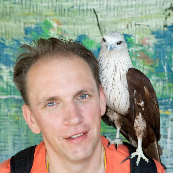 Retrato do homem com um pássaro de rapina em um ombro . — Fotografia de Stock