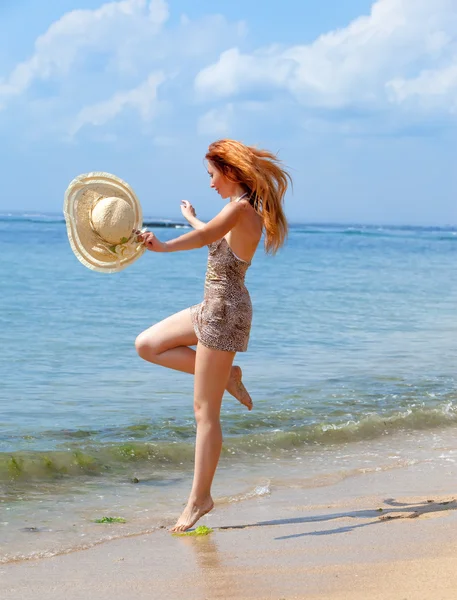 Het meisje springt op een Oceaan kust — Stockfoto