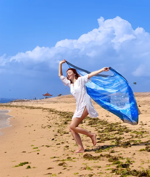 Aantrekkelijke vrouw met een sjaal strand in handen — Stockfoto