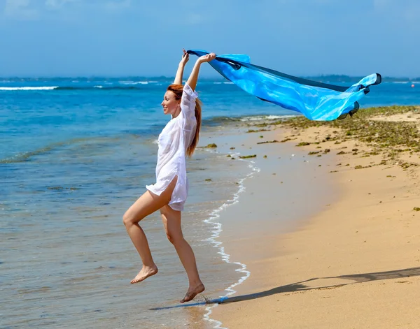 Привлекательная женщина с пляжным шарфом в руках — стоковое фото