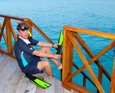 sporcu, denizde yüzmek daha önce ayak yüzgeçleri koyar.