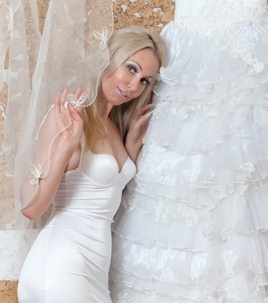 De gelukkige bruid probeert op een trouwjurk — Stockfoto