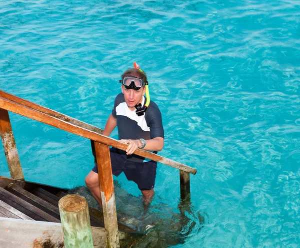 Der Sportler legt Flossen zu Fuß, bevor er im Meer schwimmt — Stockfoto