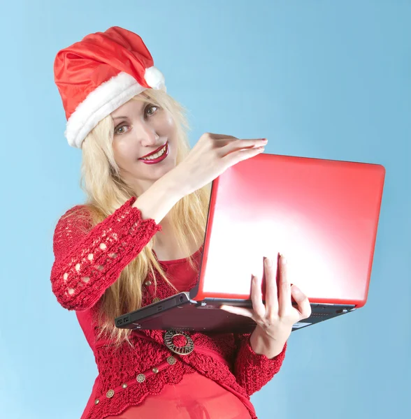 A loira no chapéu de um Ano Novo com o computador portátil vermelho — Fotografia de Stock