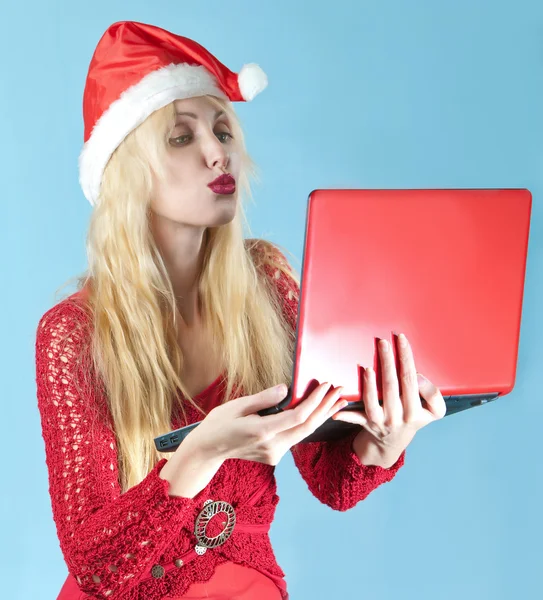 The young beautiful blonde woman in a New Year's hat with red laptop — Stock Photo, Image