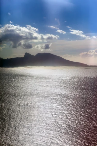 Vista aérea. silhueta de montanha no oceano ao pôr do sol. — Fotografia de Stock