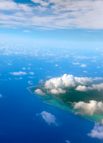 De atol ring in Oceaan is zichtbaar door wolken. Luchtfoto. — Stockfoto