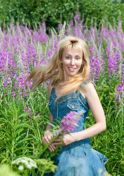 Mujer joven con ramo de flor de fuego en el campo — Foto de Stock