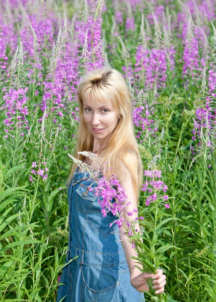 微笑着的年轻女子束报春花花卉领域 — 图库照片