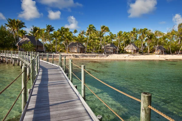 Pohled na tropickém ostrově od dřevěného mostu na pobřeží přes moře. — Stock fotografie