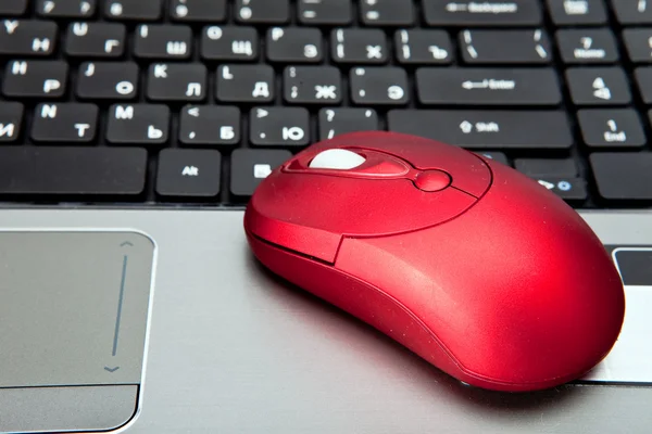 The red computer mouse on the black keyboard — Stock Photo, Image