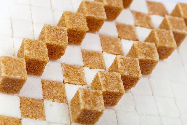 白い砂糖の上に横にリードのない洗練された砂糖のキューブ — ストック写真