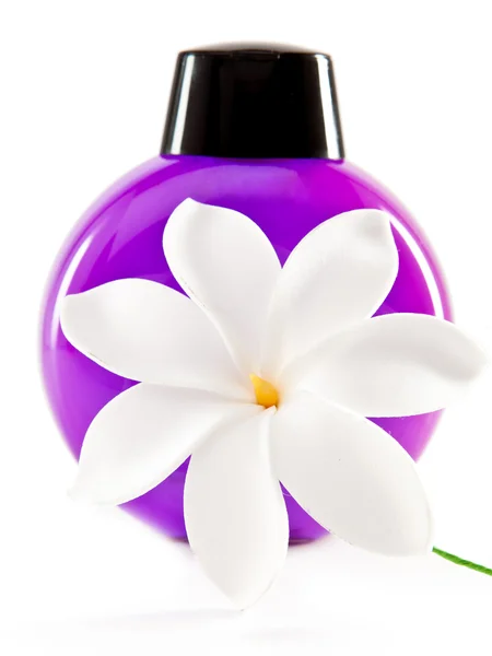 Bottle of cosmetics and white flower — Stock Photo, Image