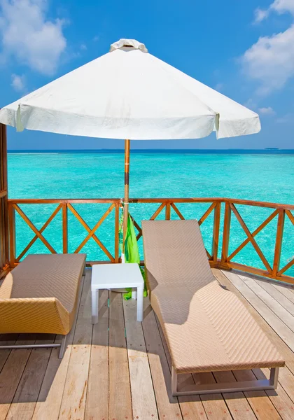 阳伞和贵妃休息室的水上别墅，马尔代夫的露台上. — 图库照片