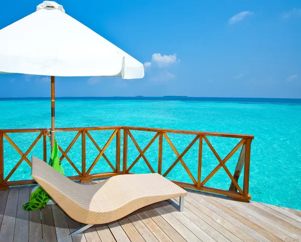 Parasol y chaise lounges en una terraza de villa de agua, Maldivas . —  Fotos de Stock