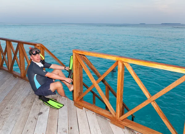 L'homme sportif met des nageoires à pied avant de nager dans la mer — Photo