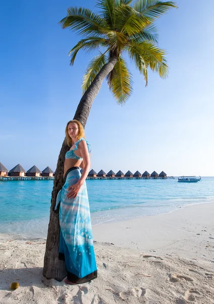 Young beautiful girl stands near by palm tree on background of ocean, Maldives — Stock Photo, Image