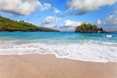 kumlu bir plaj üzerinde okyanus kayaların üzerinden görüntüleyin. Endonezya, bali