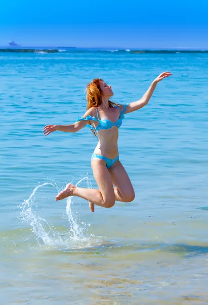 Молодая привлекательная женщина прыгает в море — стоковое фото