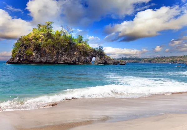 Vista desde una playa de arena sobre rocas en el océano. Indonesia, Bali — Foto de Stock