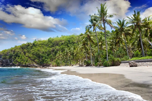 Playa de arena del mar y verdes colinas. Indonesia. Bali. — Foto de Stock