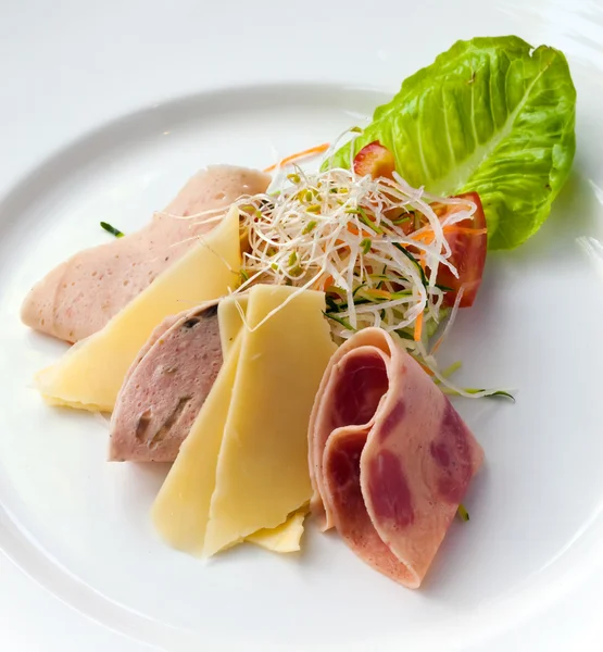 Cheese and ham are cut with slices and laid on plate — Stock Photo, Image