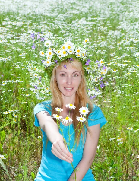 Felice giovane donna in una corona di fiori selvatici nel campo di camomilla — Foto Stock