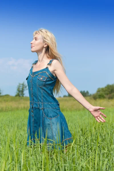 The happy young woman in the field of green ear — Stock Photo, Image