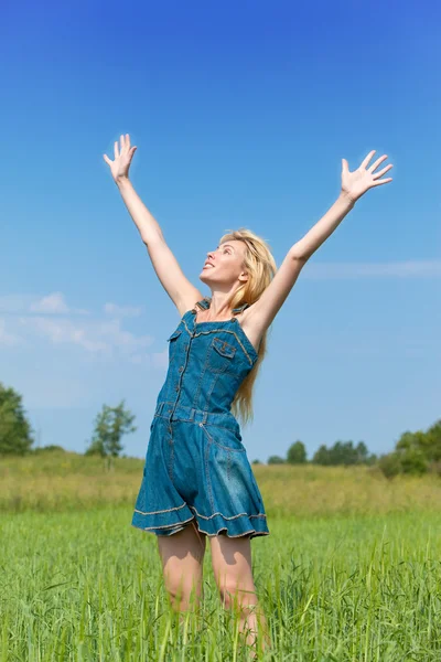 The happy young woman in the field of green ear — Stock Photo, Image