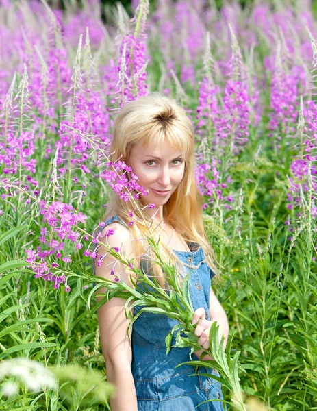 Giovane donna con mazzo di fiore di caminetto nel campo — Foto Stock