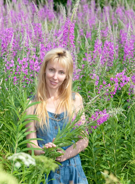 Giovane donna con mazzo di fiore di caminetto nel campo — Foto Stock