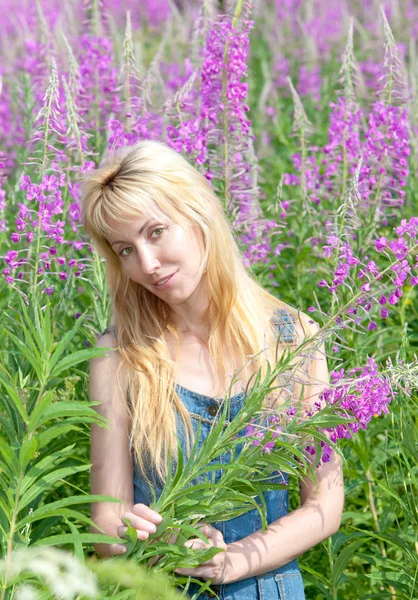Młoda kobieta z bukietem kwiatów firetop w polu — Zdjęcie stockowe