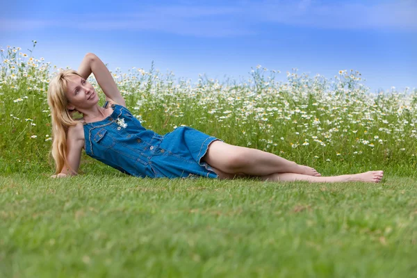 Das schöne, glückliche Mädchen liegt im Feld der Kamillen — Stockfoto