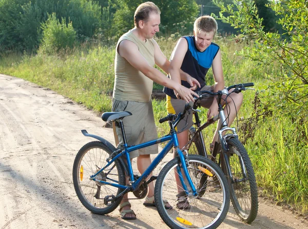 O pai com o filho em bicicletas — Fotografia de Stock