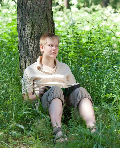 Der junge Mann mit dem Buch im Park — Stockfoto