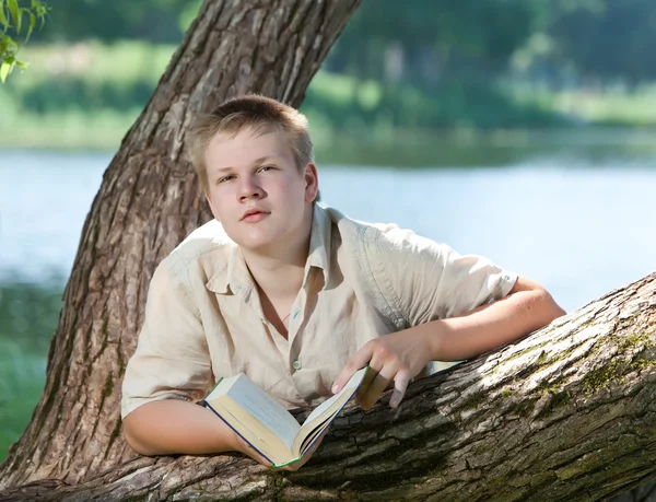 Jovem se preparar para as aulas, exame no parque da primavera perto do lago — Fotografia de Stock